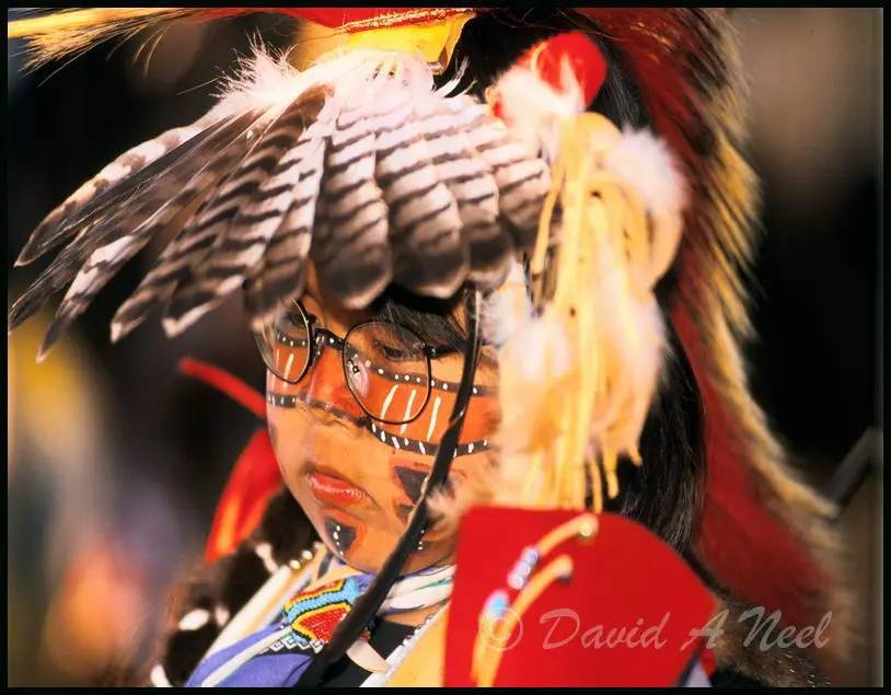 A young Native boy with Traditional dance headress and face paint.
