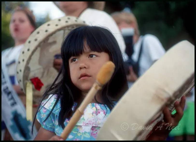 A Native American girl with a hand drum.